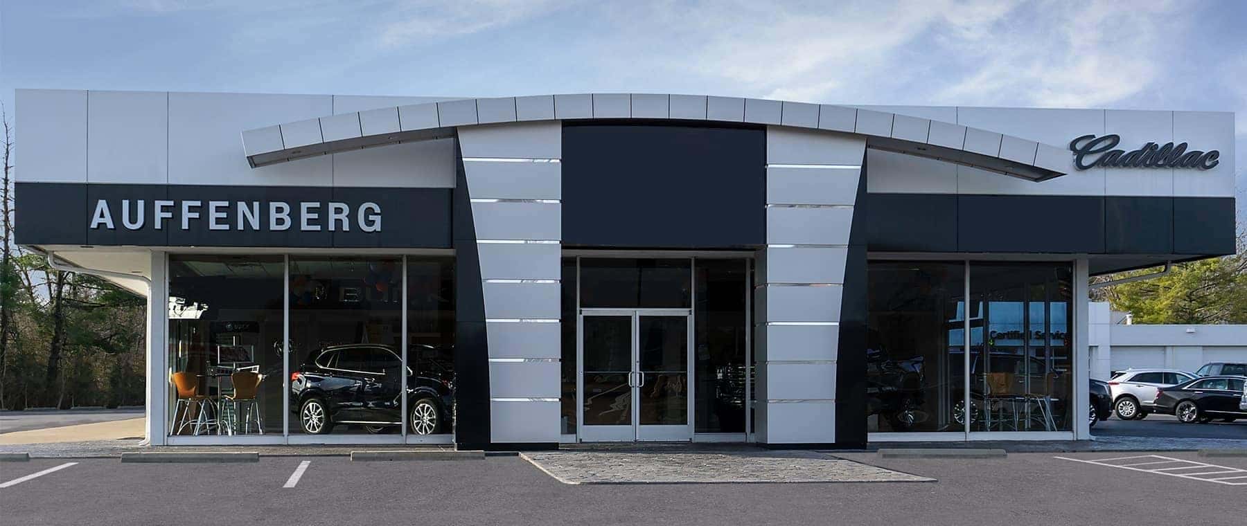 An exterior shot of a Cadillac dealership during the day