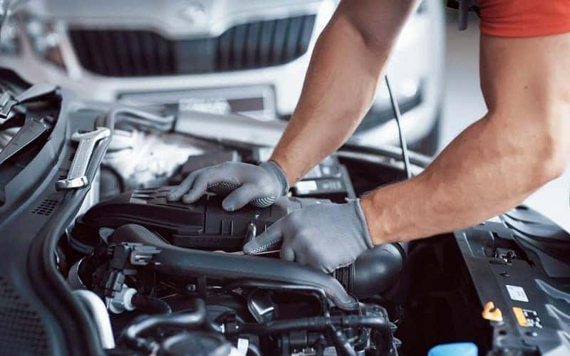 Close up of Mazda service technician working on Mazda engine