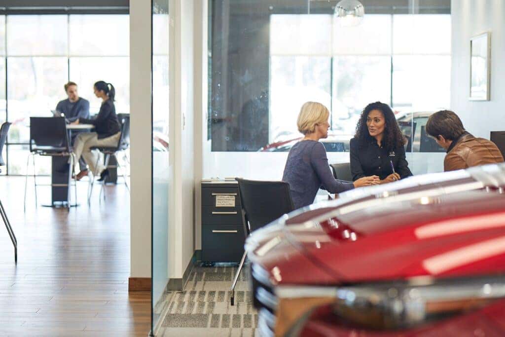 Customers discussing a Mazda lease with a dealer
