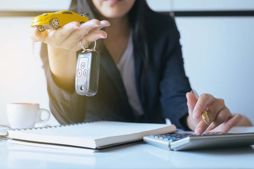 Reviewing Mazda financing options with a notepad and calculator