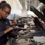 Technician inspecting a vehicle at a Mazda service center
