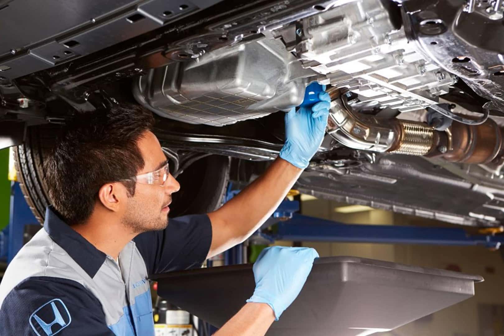honda service technician working under vehicle