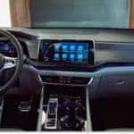 Interior dashboard and steering wheel of a 2026 Volkswagen Atlas featuring ambient lighting and digital displays.