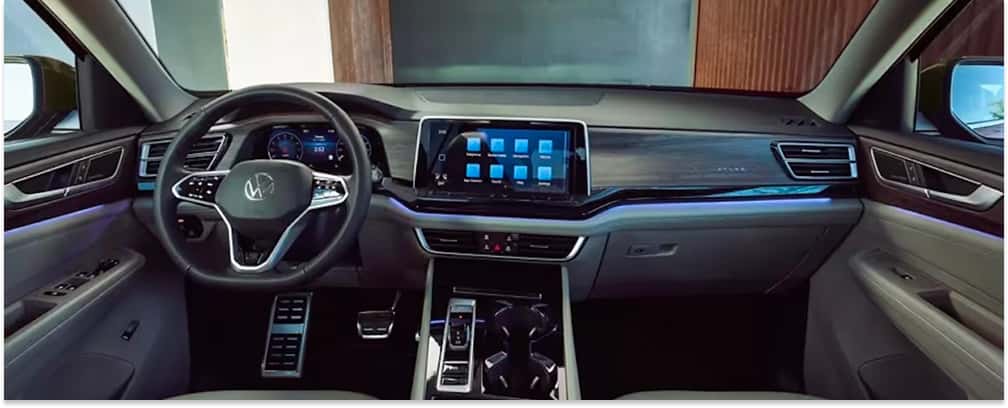 Interior dashboard and steering wheel of a 2026 Volkswagen Atlas featuring ambient lighting and digital displays.