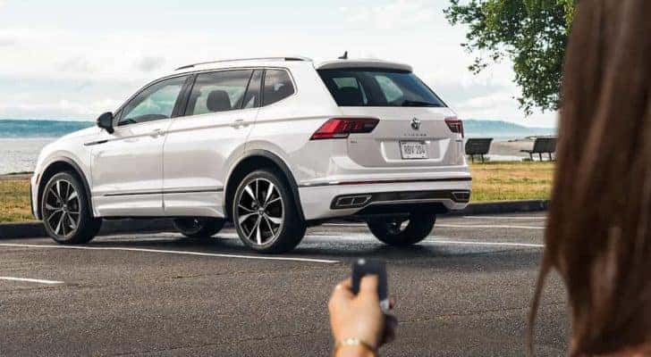 A white 2022 Volkswagen Tiguan is shown from the rear in a parking lot.