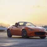 orange mazda miata mx-5 roadster parked on road