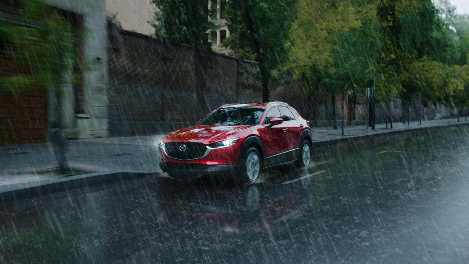 Soul Red Mazda Cx-5 Driving down the road in the rain