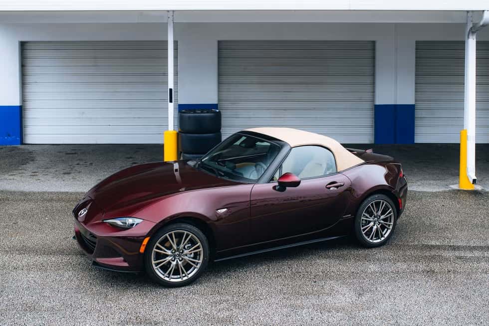 red mazda miata parked with a tan roof
