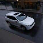 Overhead shot of a white 2025 Mazda CX-5 driving down the road. The CX-5 is white in color.