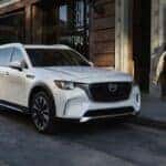 A white Mazda CX-90 parked next to a curb
