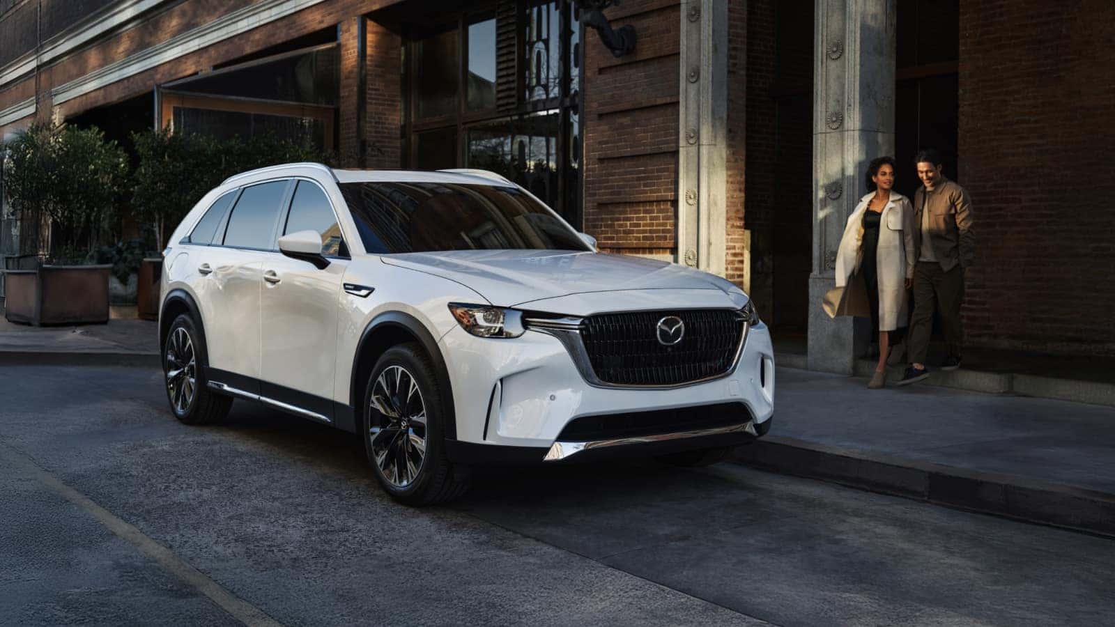 A white Mazda CX-90 parked next to a curb