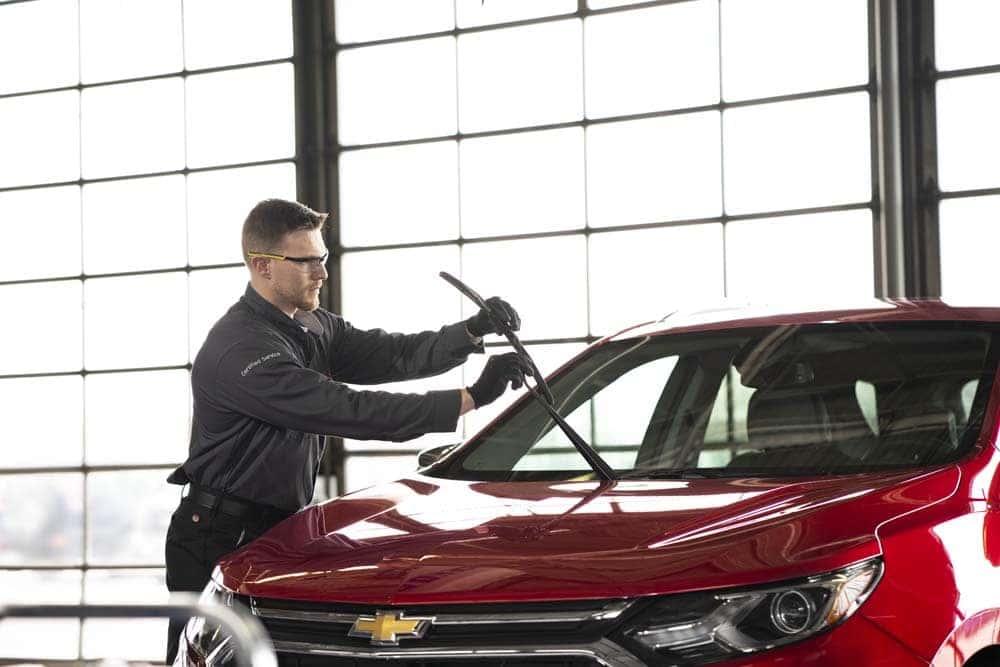 A mechanic performing windshield wiper replacement