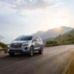 A 2023 Chevy Equinox driving along a mountainous road