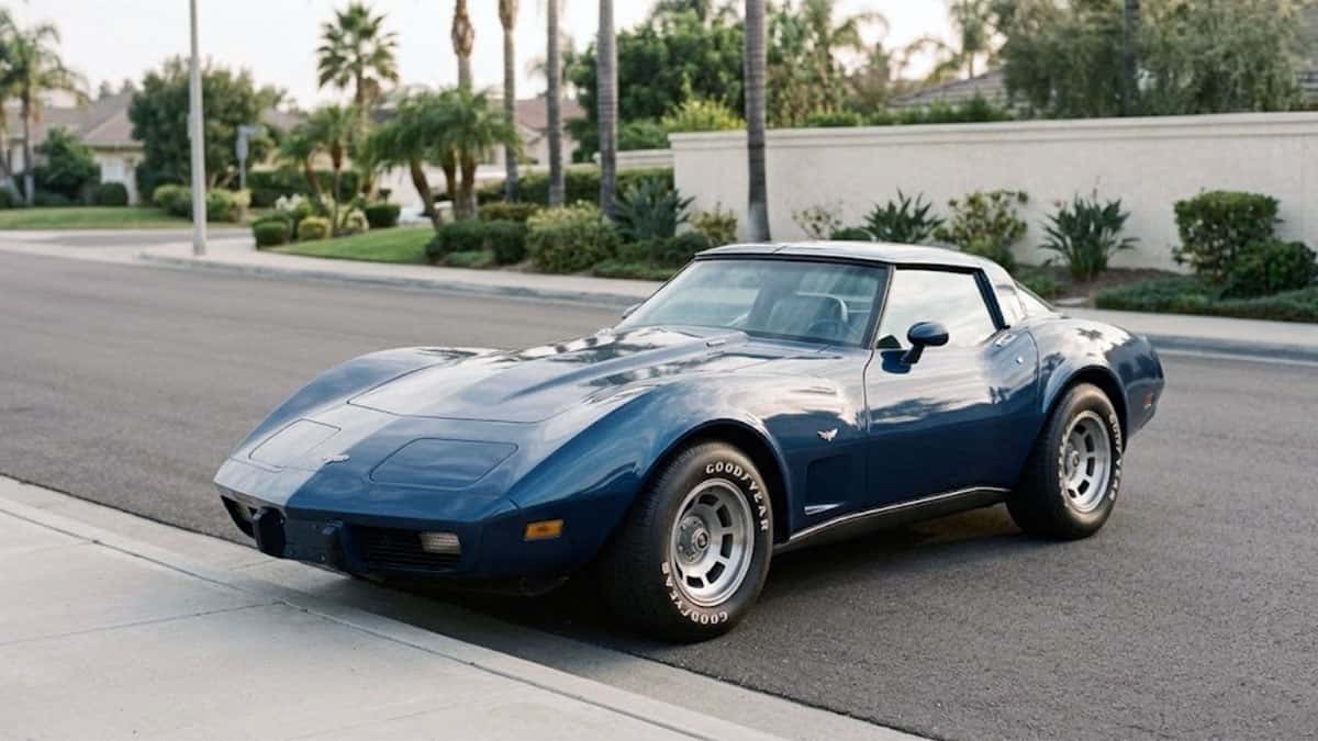 Blue classic Chevrolet Corvette parked at a curb on a palm-lined residential street