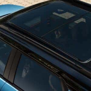 Overhead view of the 2025 Chevrolet Trailblazer in blue, showcasing its panoramic sunroof and sleek roofline design with visible occupants inside.