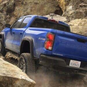 Rear view of a Chevrolet Colorado parked on snow-covered ground, showcasing the Trail Boss badge and rugged design.