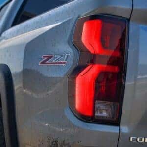 Close-up of the rear badge and taillight of a Chevrolet Colorado Z71 on a sunny day.