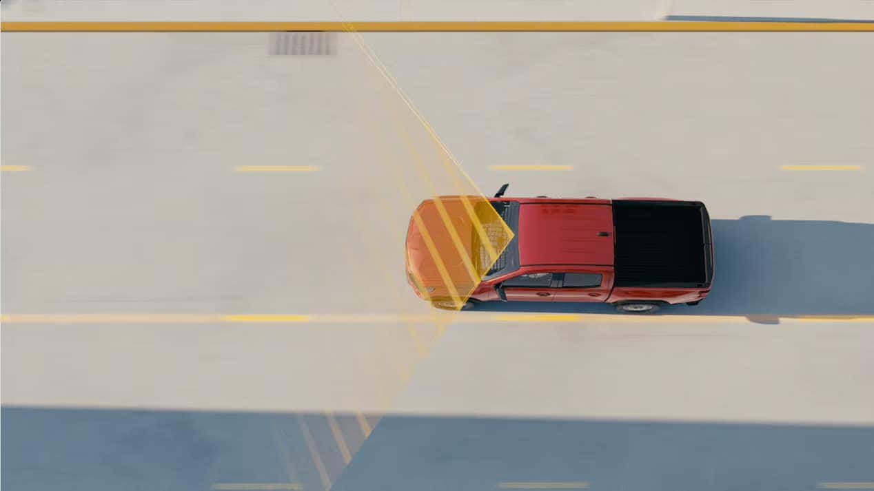 Top-down view of a red Chevrolet Colorado demonstrating lane-keeping assist technology with highlighted detection zones.