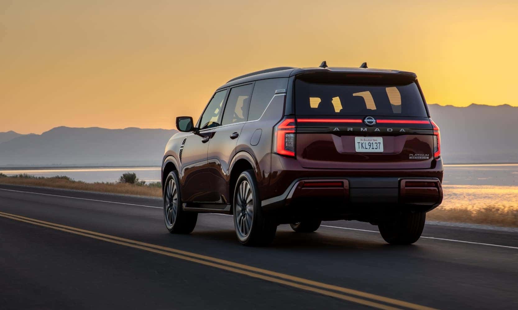 a 2025 Nissan Armada SUV driving down an open road at sunset