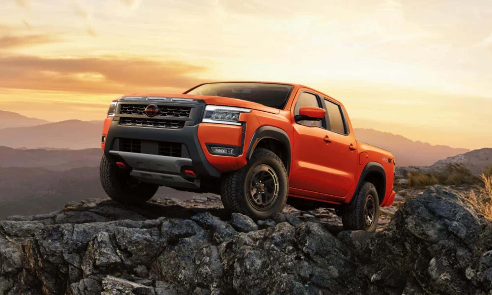 A side image graphic of an orange 2025 Nissan Frontier exterior dimensions parked in an open field with trees behind it