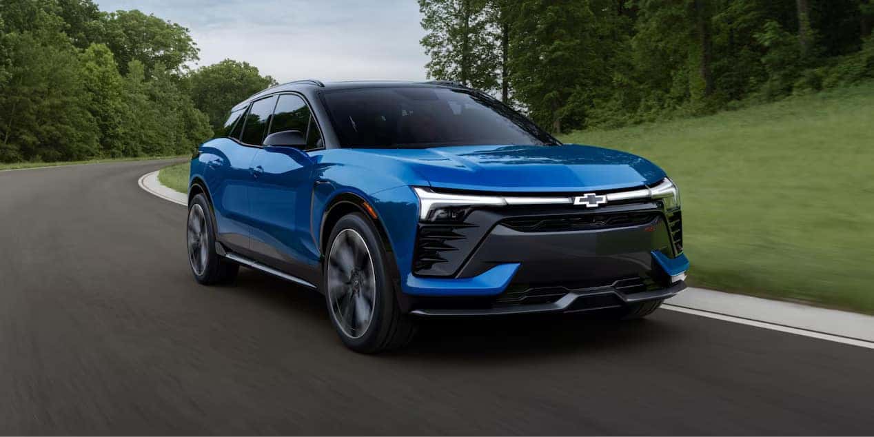a blue electric SUV driving on a road