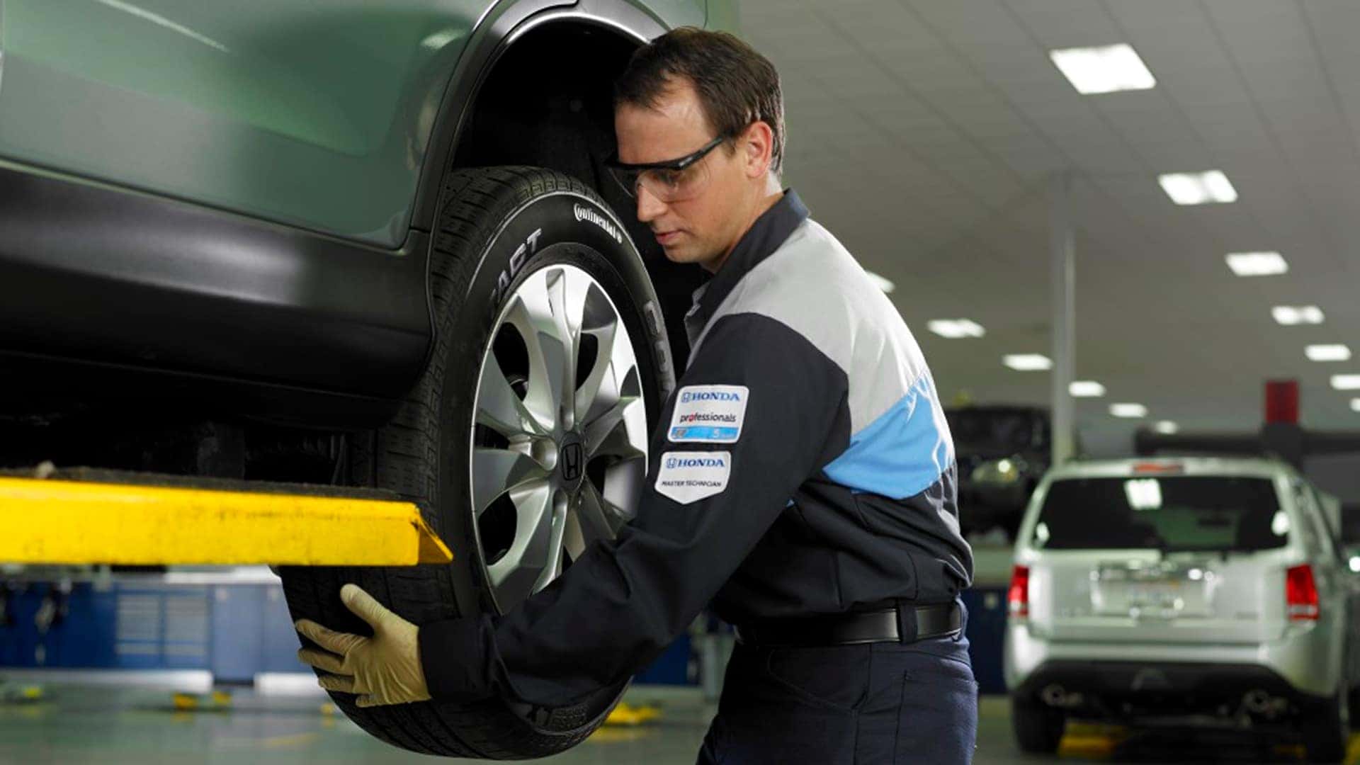 honda service technician working on tire