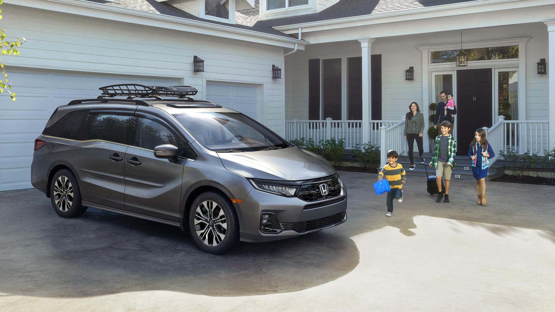 family standing next to 2025 honda odyssey parked in front of house