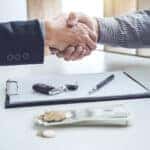Handshake of cooperation customer and salesman after agreement, successful car loan contract buying or selling new vehicle.