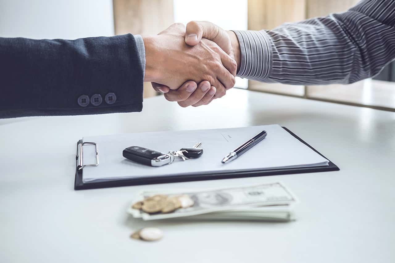 Handshake of cooperation customer and salesman after agreement, successful car loan contract buying or selling new vehicle.