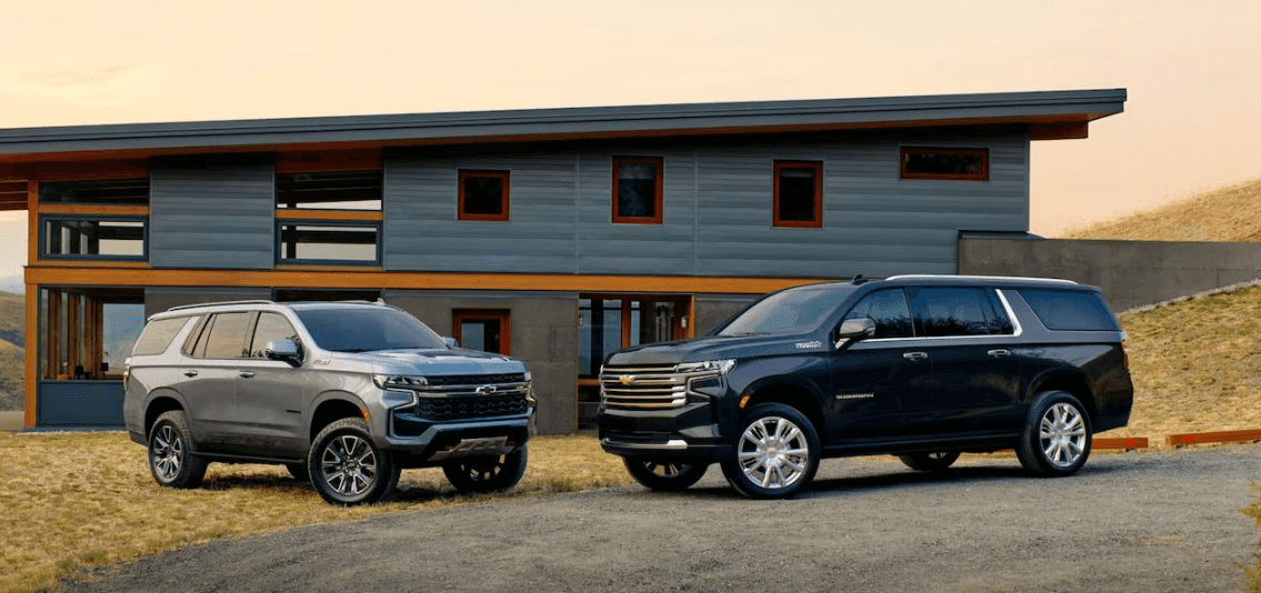 Chevrolet Suburban and Tahoe parked outside modern home