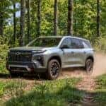 Chevrolet Traverse driving on wooded dirt trail