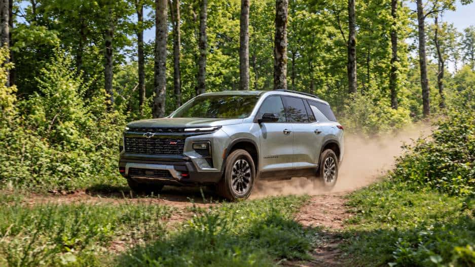 Chevrolet Traverse driving on wooded dirt trail