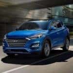 The 2021 Hyundai Tucson driving in a city.