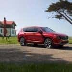 A red Hyundai Santa Fe parked in front of a house.