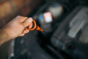 Using a dip-stick to check the oil level in a VW Passat