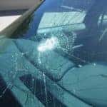 A car windshield with a massive crack from something large impacting it.