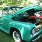 A classic teal truck on display at a local auto show.
