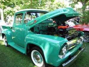 A classic teal truck on display at a local auto show.