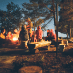 Kids sitting around a nighttime campfire in a Marion, IL summer camp.