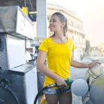 Woman in a yellow shirt fueling up her Volkswagen at a Marion, IL gas pump.