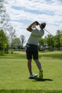 Man swinging a golf club at a Marion, IL golf course.