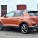 Volkswagen of Tiguan in orange paint photographed from the rear.