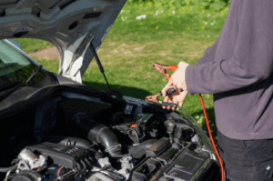 Person jumpstarting a dead Volkswagen battery.