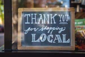 Thank you for shopping local sign hanging in Marion, IL business window.