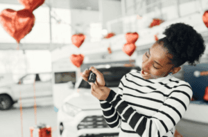 Woman holding a car key in a Marion, IL Volkswagen dealership.