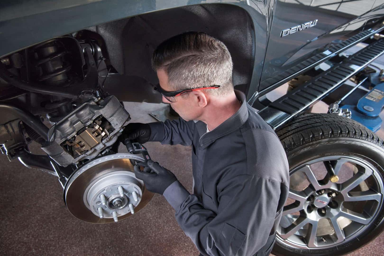 Buick GMC technician working on GMC Yukon Denali.