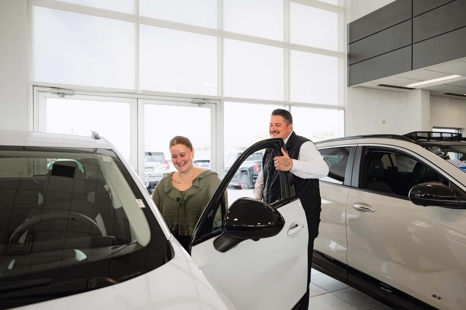 A Walser consultant showing a customer a new vehicle in the Roseville showroom